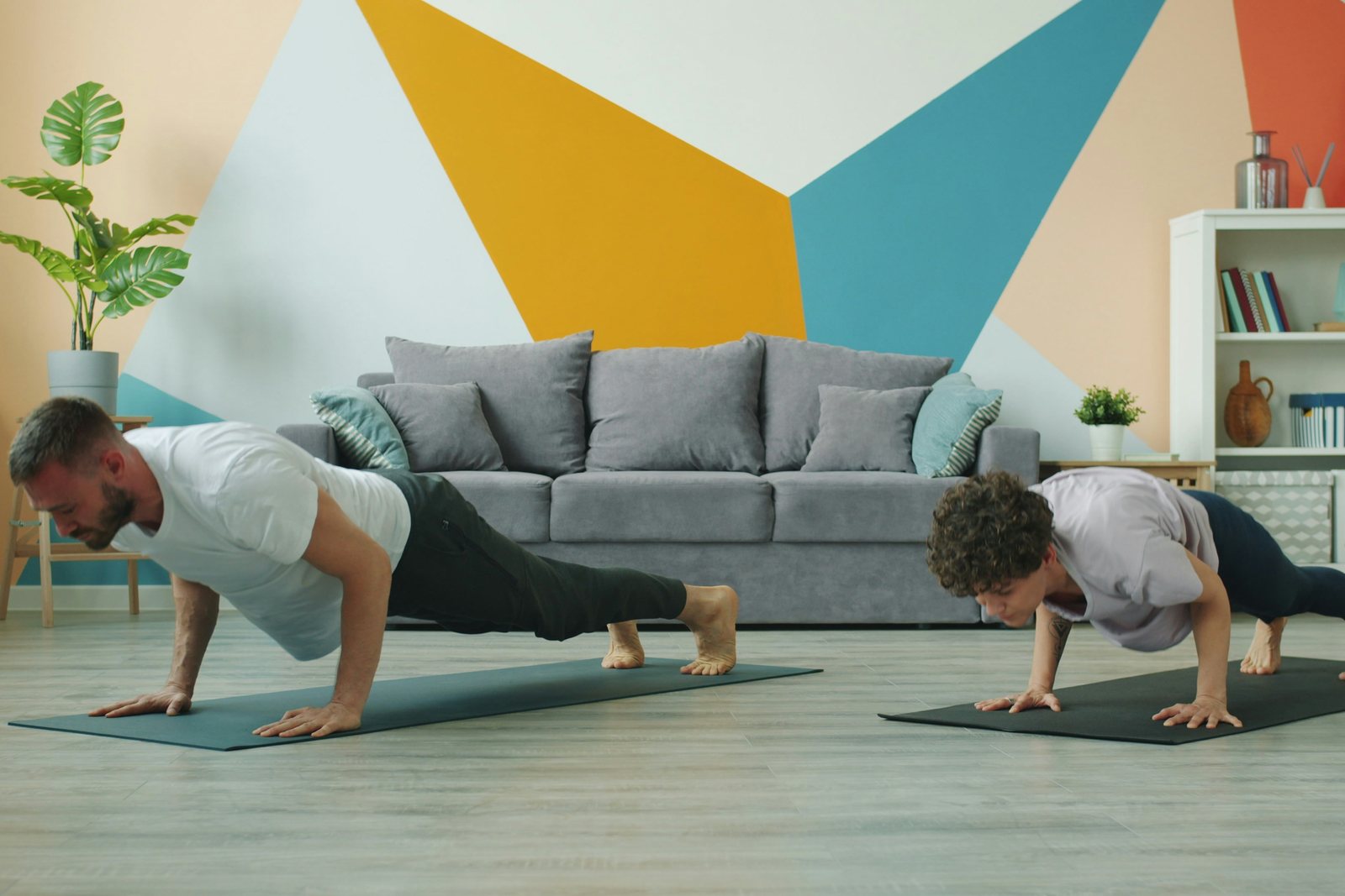 An adult and a child doing push-ups on exercise mats