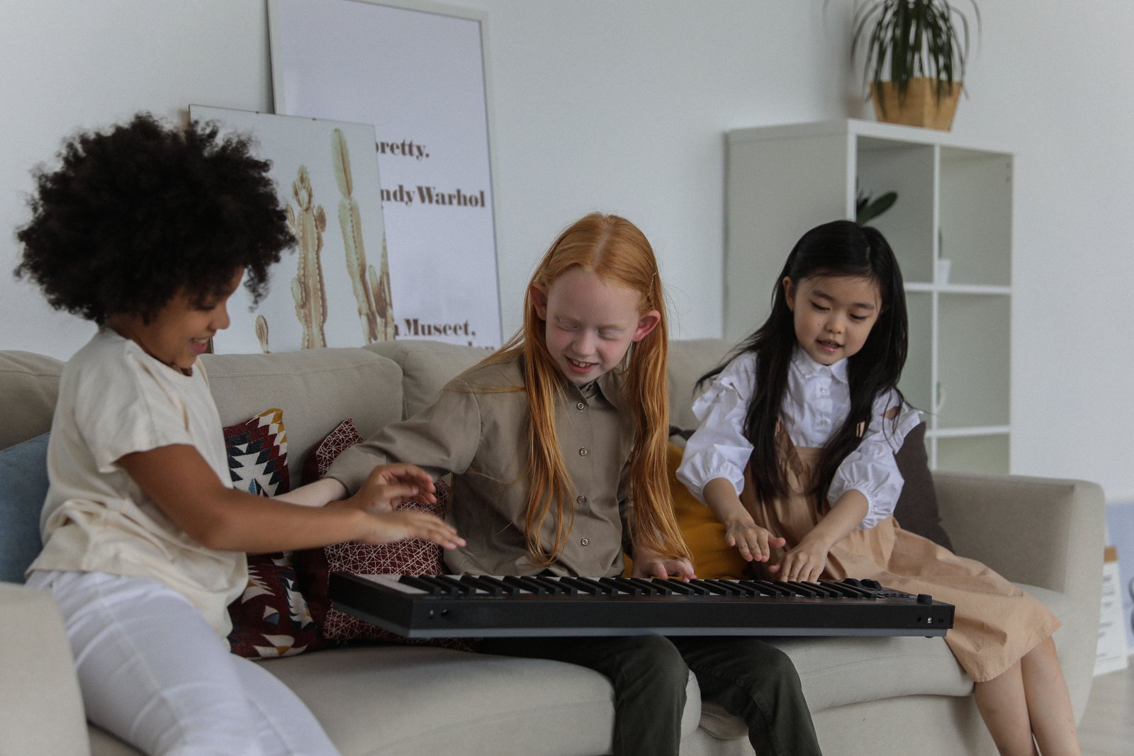 Three children sharing a keyboard and playing together